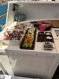 A beautifully arranged spread of fresh salads and fruits on a boat, perfect for catering during a day on the water.