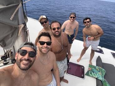 A group of friends enjoys a fun day on the boat, capturing the moment with smiles and drinks under the sun — perfect for a memorable celebration at sea.