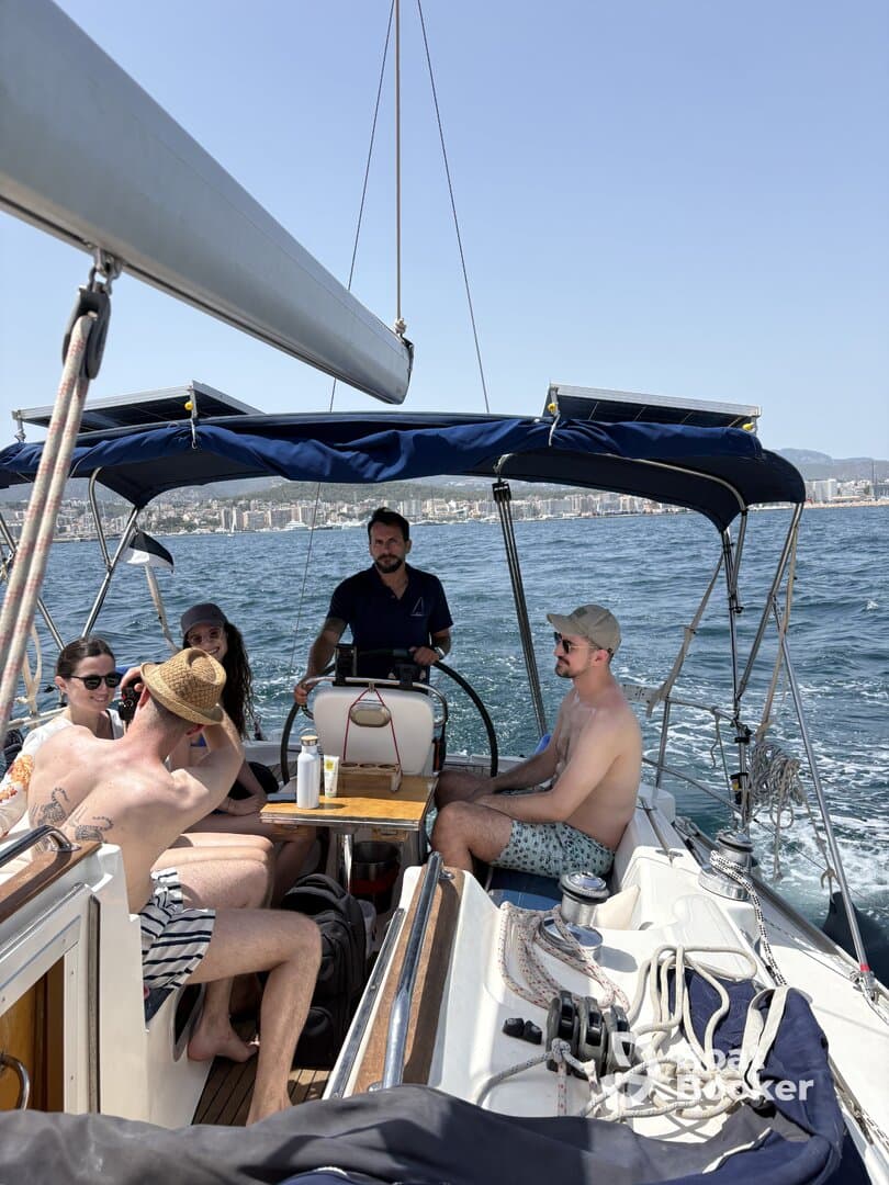 A lively group enjoys a sailing experience on a sunny day, with friends gathered on deck, creating unforgettable memories on the water.