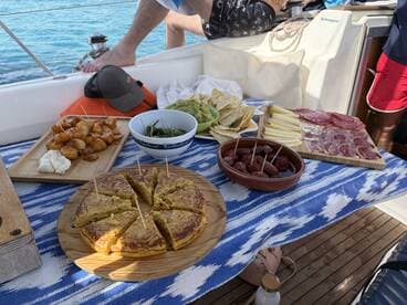 A delicious spread of tapas and snacks laid out on a boat, perfect for enjoying while sailing in beautiful waters.