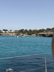 A picturesque view of boats navigating through turquoise waters, with a beautiful coastline in the background — perfect for showcasing scenic boat trips.