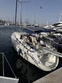 A sleek yacht named 'Servus' docked in a marina, surrounded by other vessels — perfect for exploring coastal destinations.