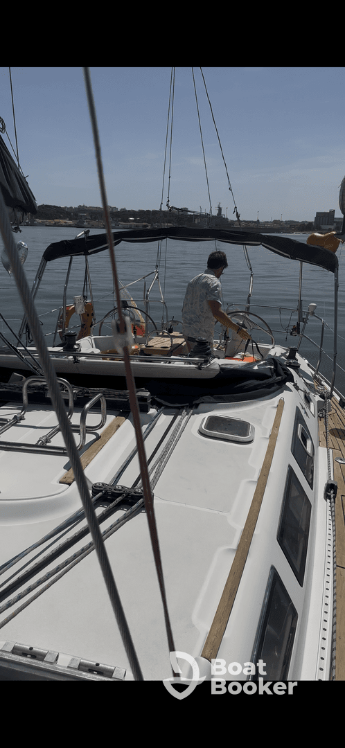 A sailor navigates the helm of a yacht, showcasing the interior setup and seating arrangements, perfect for a day on the water.