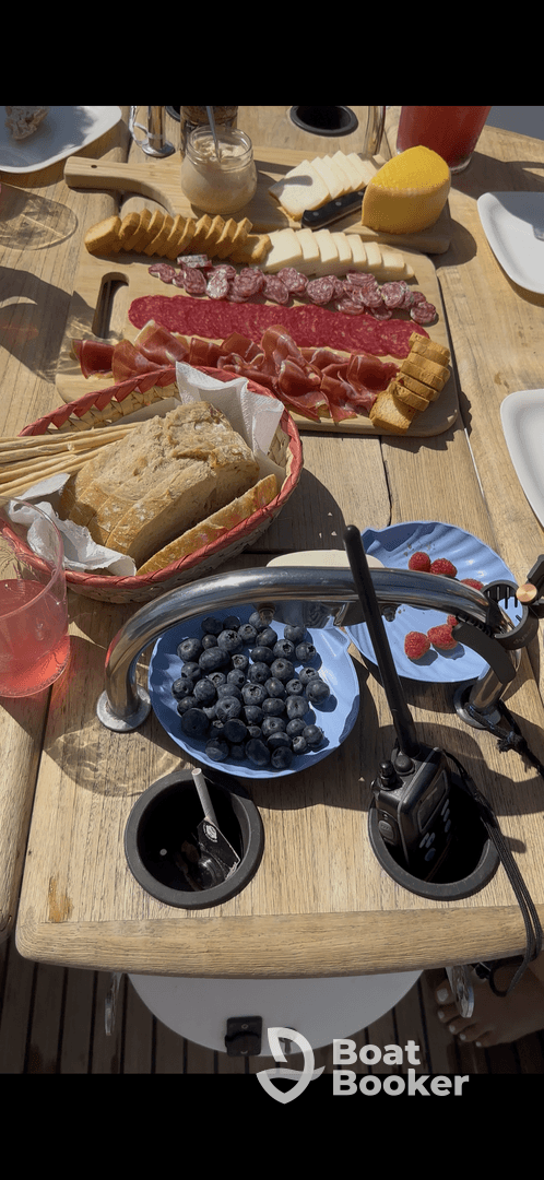 A beautifully arranged charcuterie spread featuring bread, cheeses, and fresh berries, perfect for enjoying on a boat trip.