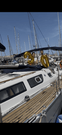A couple celebrates a 30th birthday aboard a yacht, holding festive balloons against a backdrop of sailboats in the marina.