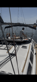 A sailor navigates the helm of a yacht, showcasing the interior setup and seating arrangements, perfect for a day on the water.