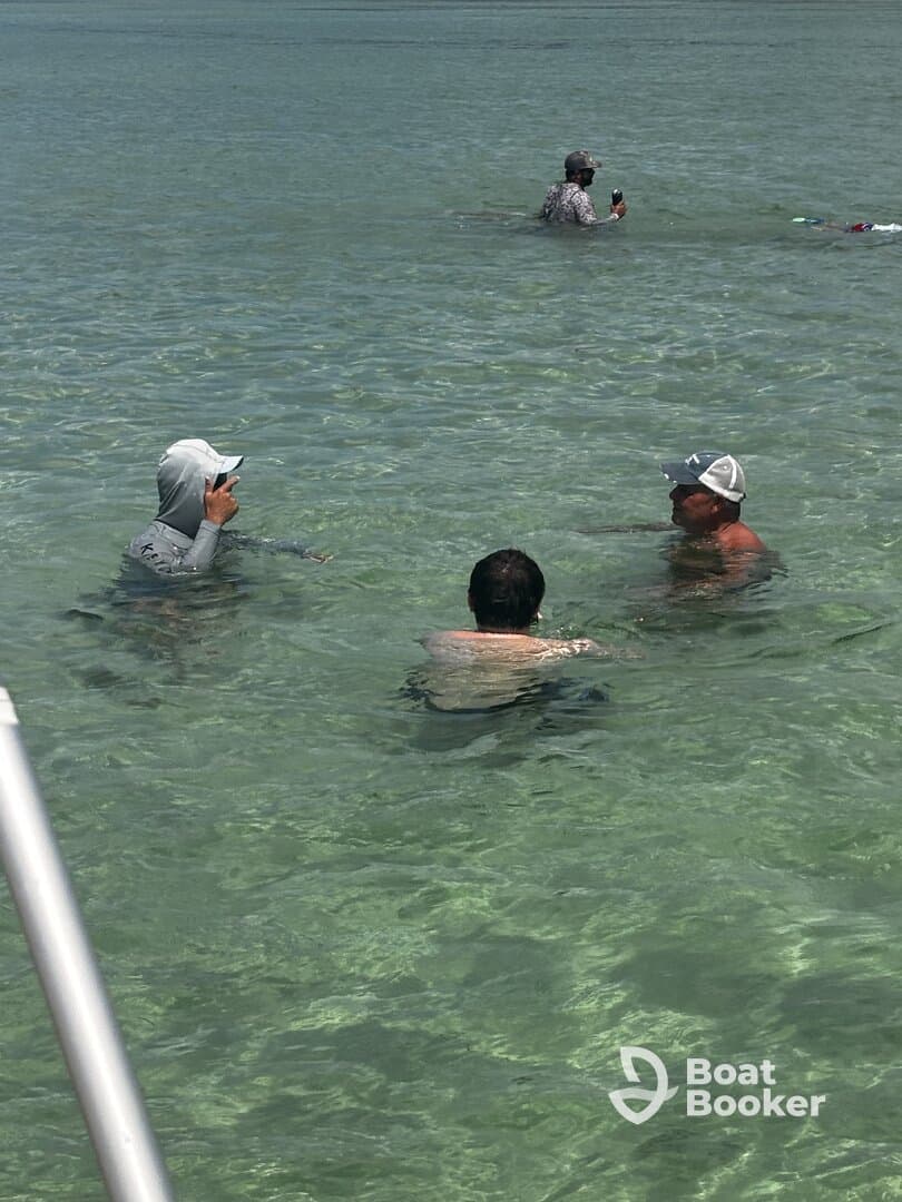 A group of friends enjoys a refreshing swim in crystal-clear waters, capturing the essence of a perfect day on the water.