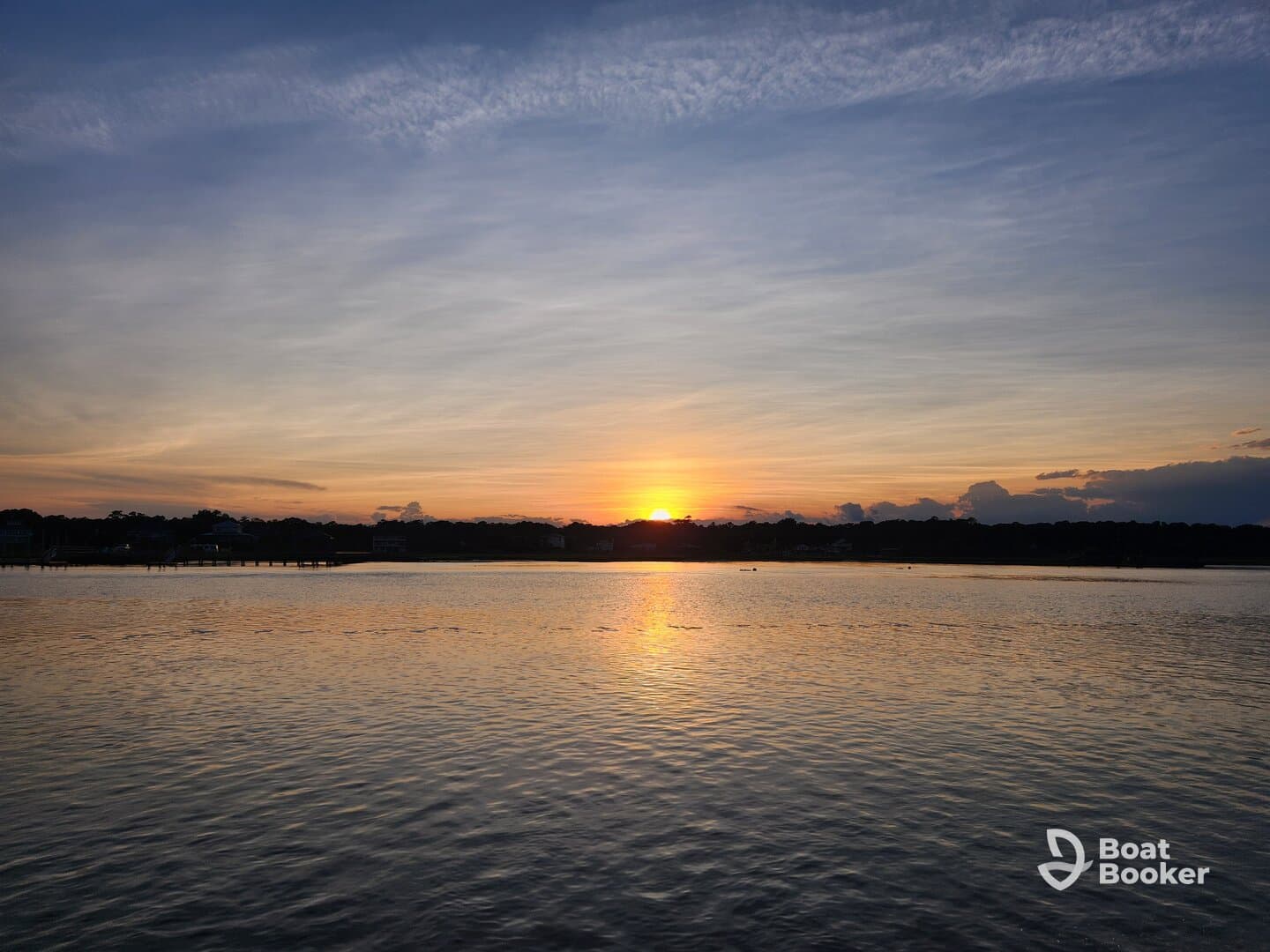 A stunning sunset casts vibrant colors over the water, creating a picturesque scene perfect for evening boat cruises or relaxation by the shore.
