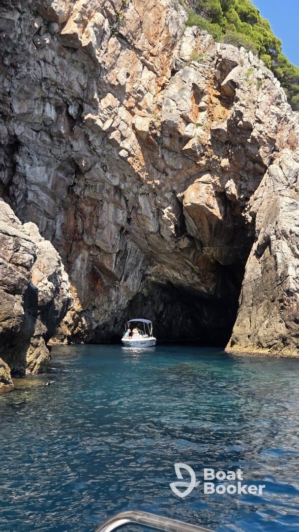 A boat navigates through a stunning cave, showcasing the natural beauty of the coastline — perfect for adventure seekers exploring hidden gems on the water.