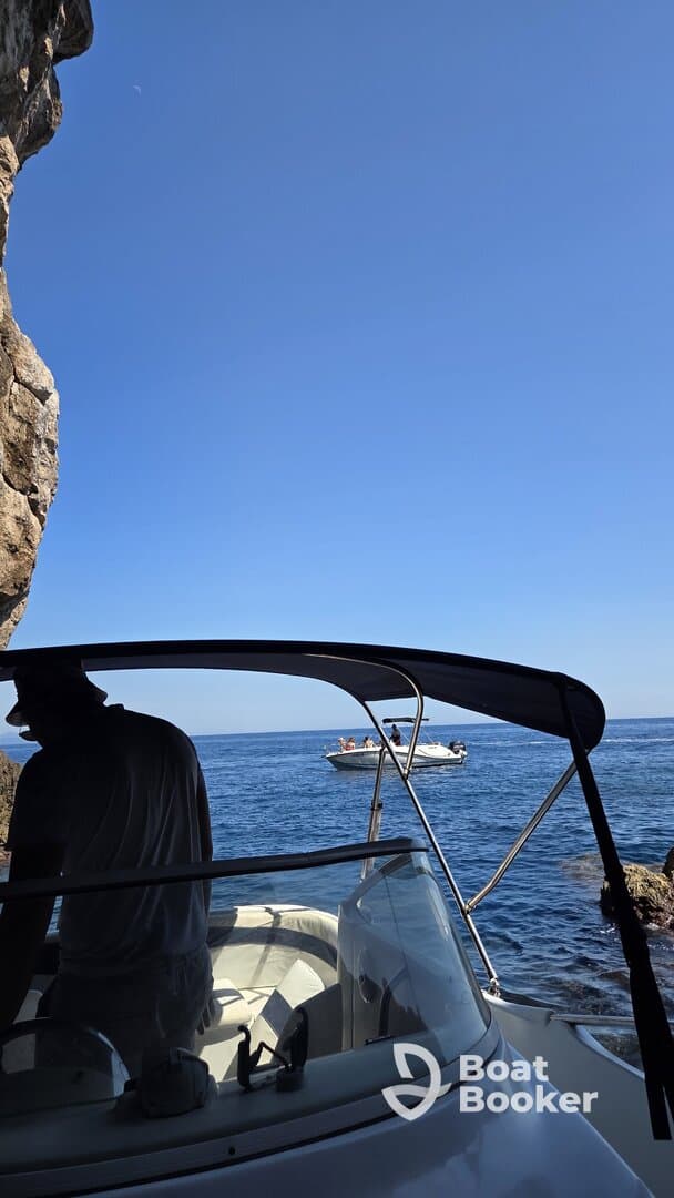 A scenic view from the deck of a boat, showcasing another vessel in the distance with people onboard, perfect for capturing the essence of a day on the water.
