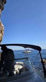 A scenic view from the deck of a boat, showcasing another vessel in the distance with people onboard, perfect for capturing the essence of a day on the water.