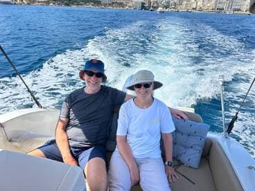 A happy couple relaxes on a boat, enjoying the beautiful water views — perfect for a day of leisure on the sea.