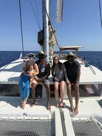 A joyful group of friends and family relaxes on a catamaran, enjoying their time on the water. Perfect for family outings and memorable celebrations.