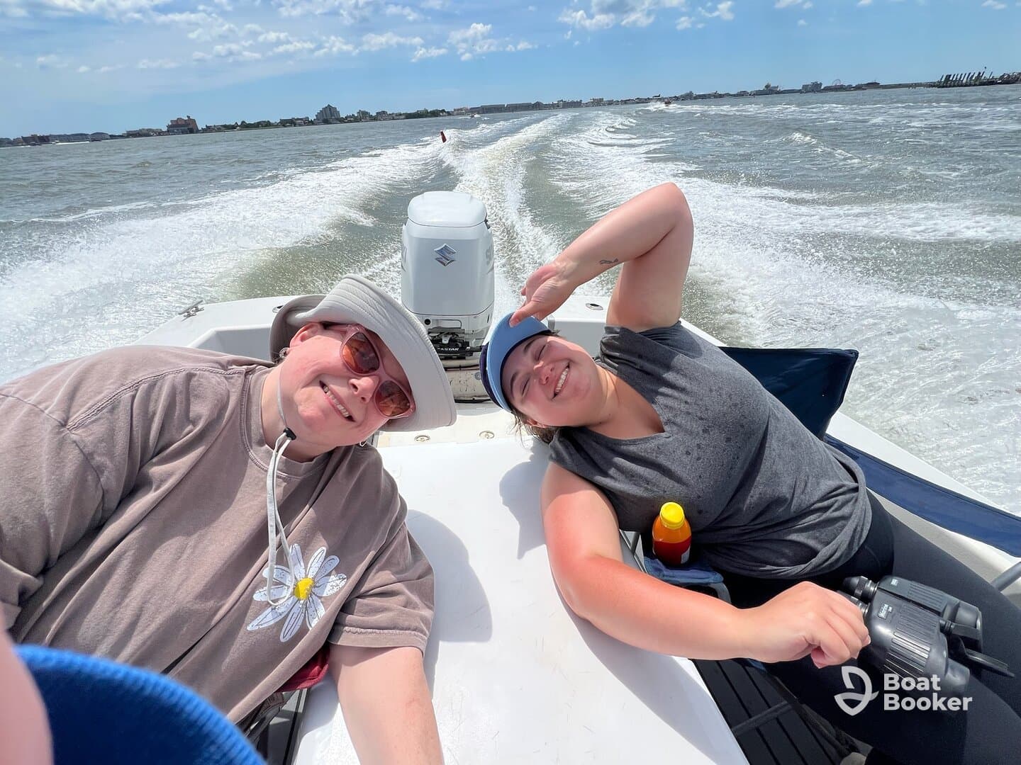 Two friends enjoy a sunny day on the water, capturing fun moments while boating — perfect for creating lasting memories on the sea.