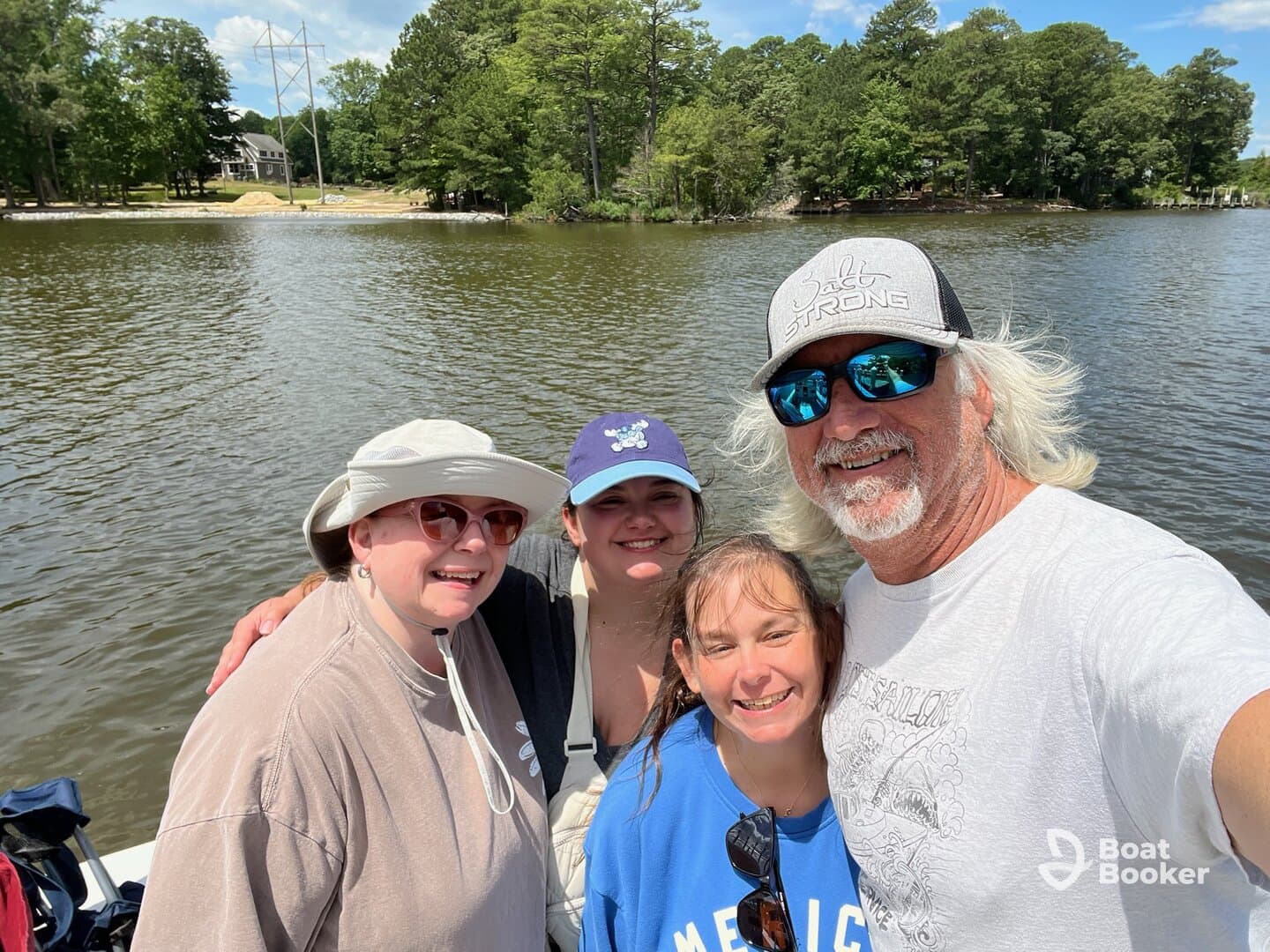 A joyful family takes a selfie on a boat, capturing a memorable day on the water surrounded by nature.