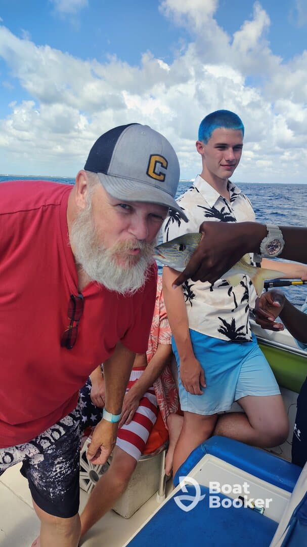 A lively group enjoys a fishing experience on a boat, showcasing their catch and capturing fun moments together — perfect for family outings or group adventures on the water.