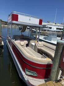 A well-maintained pontoon boat docked at the marina, showcasing its spacious seating and inviting design, perfect for leisurely outings on the water.