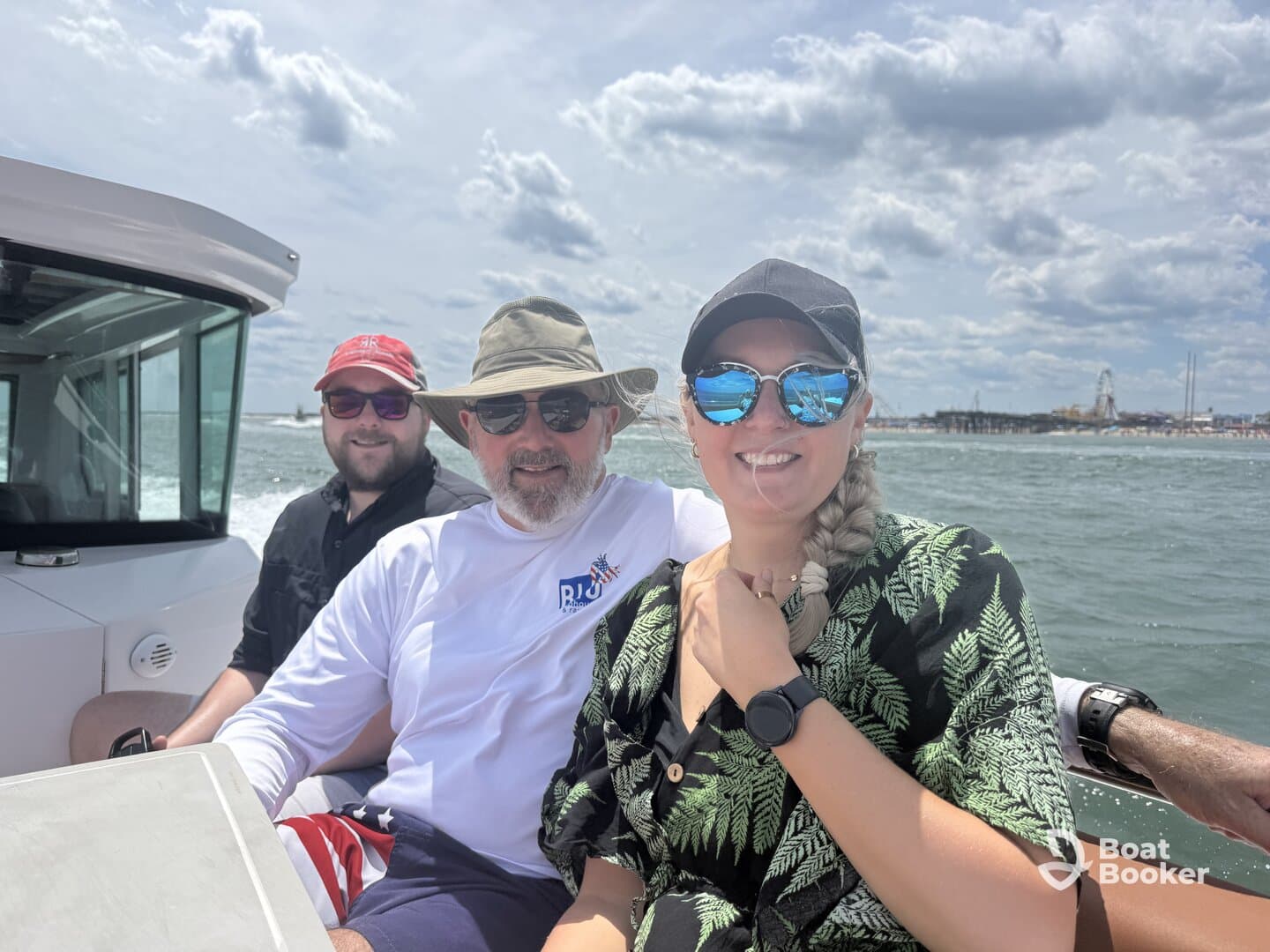 A cheerful group enjoys a sunny day on the water, capturing memories aboard their boat with a scenic pier in the background.