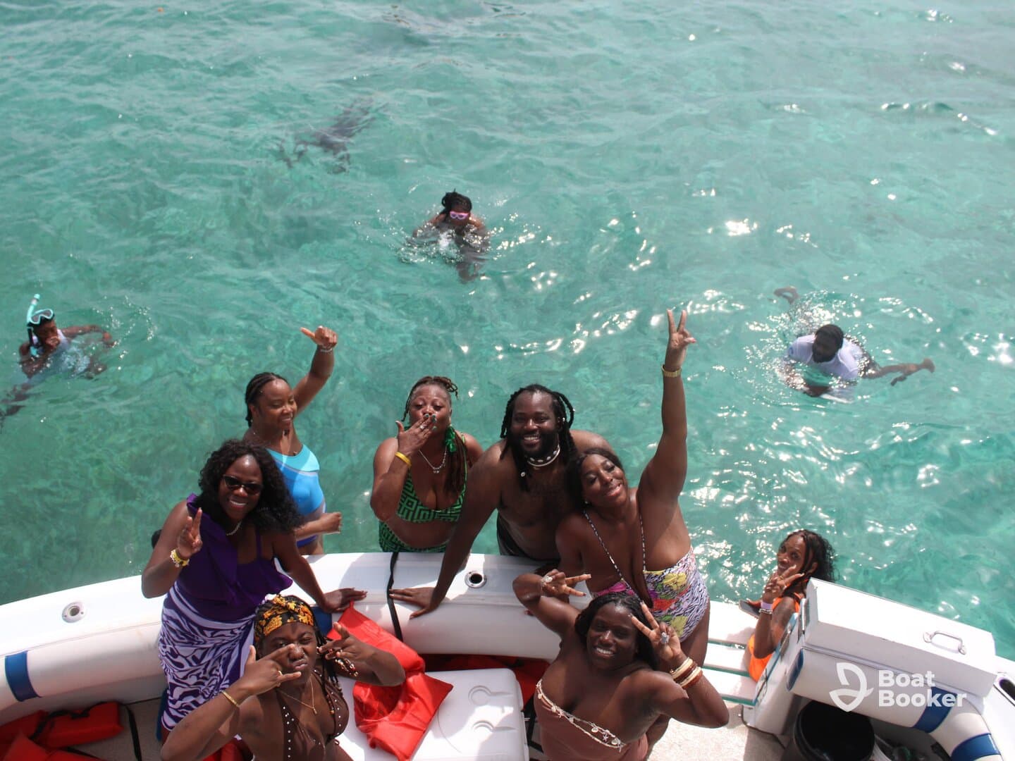 A lively group enjoys a fun day on the water, swimming and snorkeling in crystal-clear waters, creating unforgettable memories together.