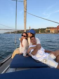 A joyful group enjoys a sunset cruise on a yacht, capturing a moment of togetherness against a stunning backdrop of the city skyline.