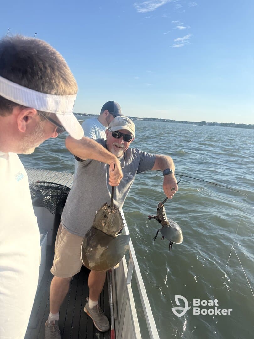 A group of friends proudly displays their catch while fishing on the water, showcasing the excitement of a successful day out on the boat.