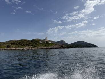 A picturesque view of a lighthouse on an island, surrounded by serene waters and lush greenery, perfect for showcasing coastal adventures.