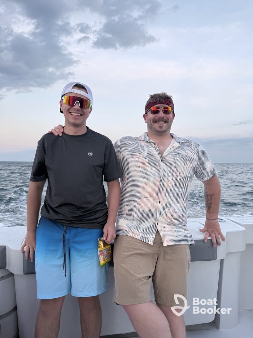 Two friends pose for a cheerful photo on a boat, enjoying their time at sea with smiles and stylish sunglasses — perfect for capturing memorable moments on the water.