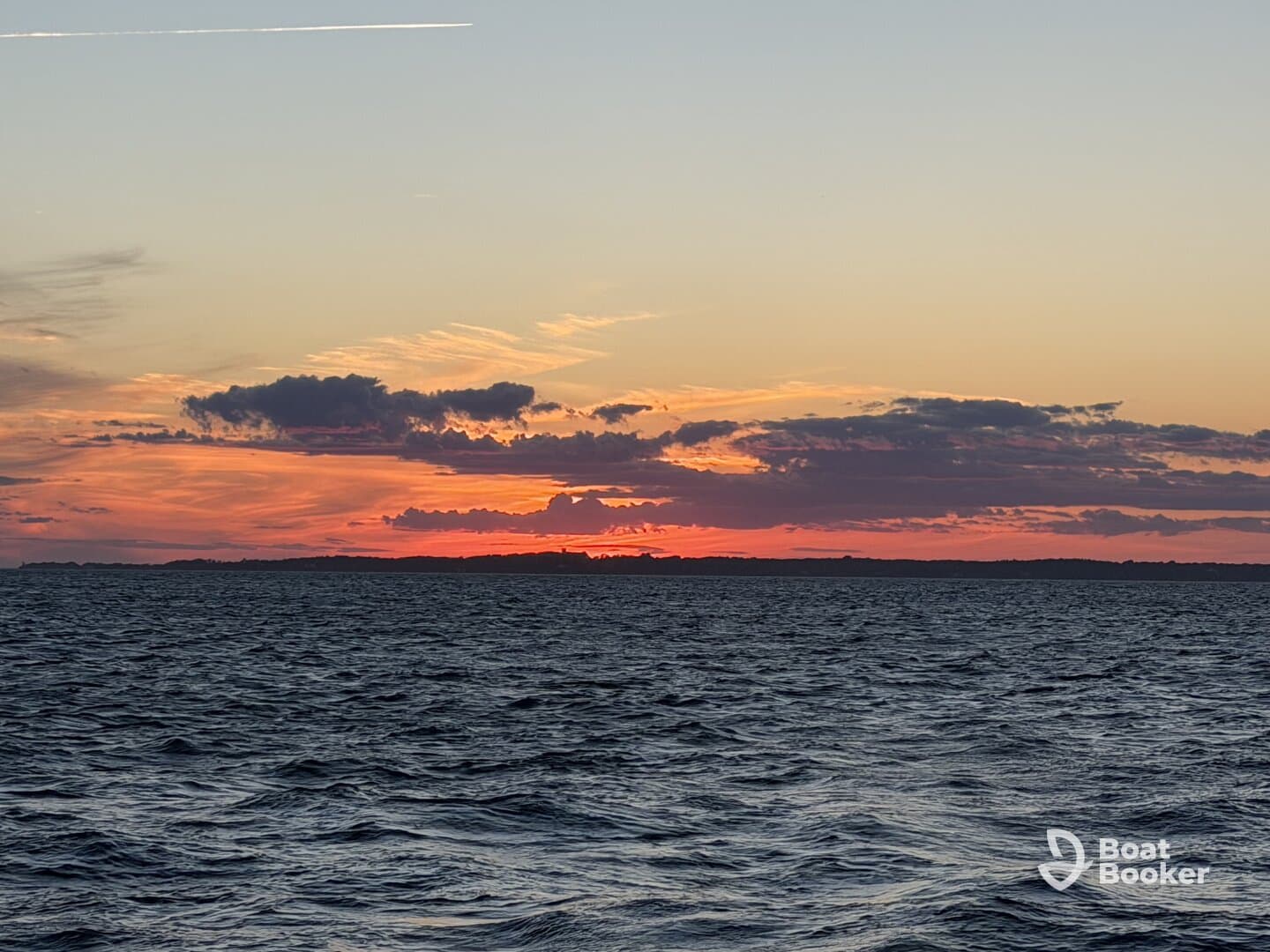A stunning sunset over the water, showcasing vibrant colors against the horizon — an ideal backdrop for evening boat cruises.