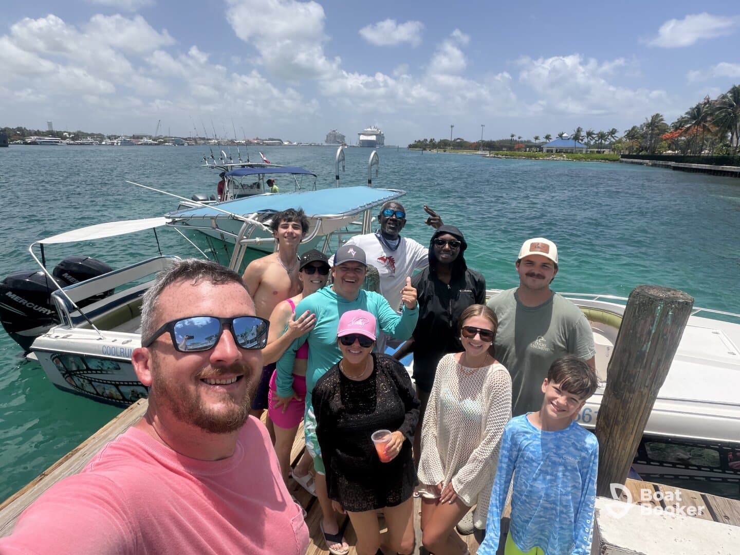 A cheerful group poses for a selfie on the dock beside their boat, ready for a fun day on the water — perfect for family outings or group adventures.