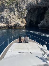 A couple enjoys the stunning coastal views from the bow of a yacht, creating a perfect backdrop for a romantic getaway.