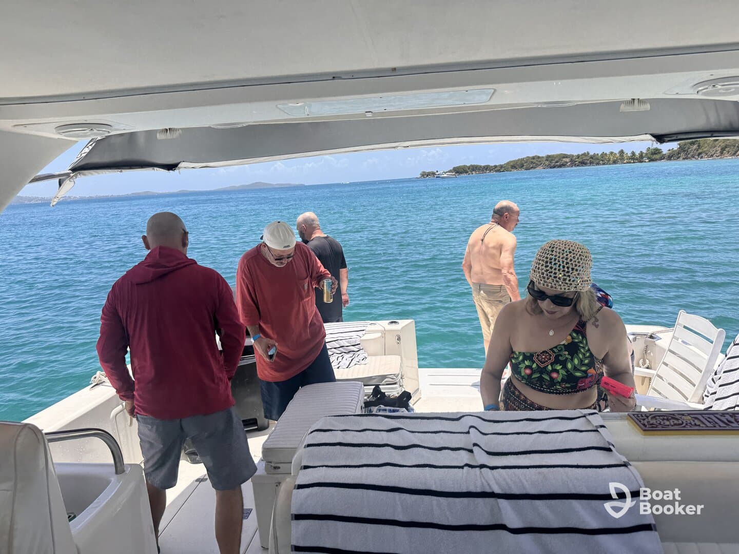 A group of friends enjoys a sunny day on the boat, with drinks in hand and the beautiful ocean as their backdrop — perfect for a relaxing getaway.