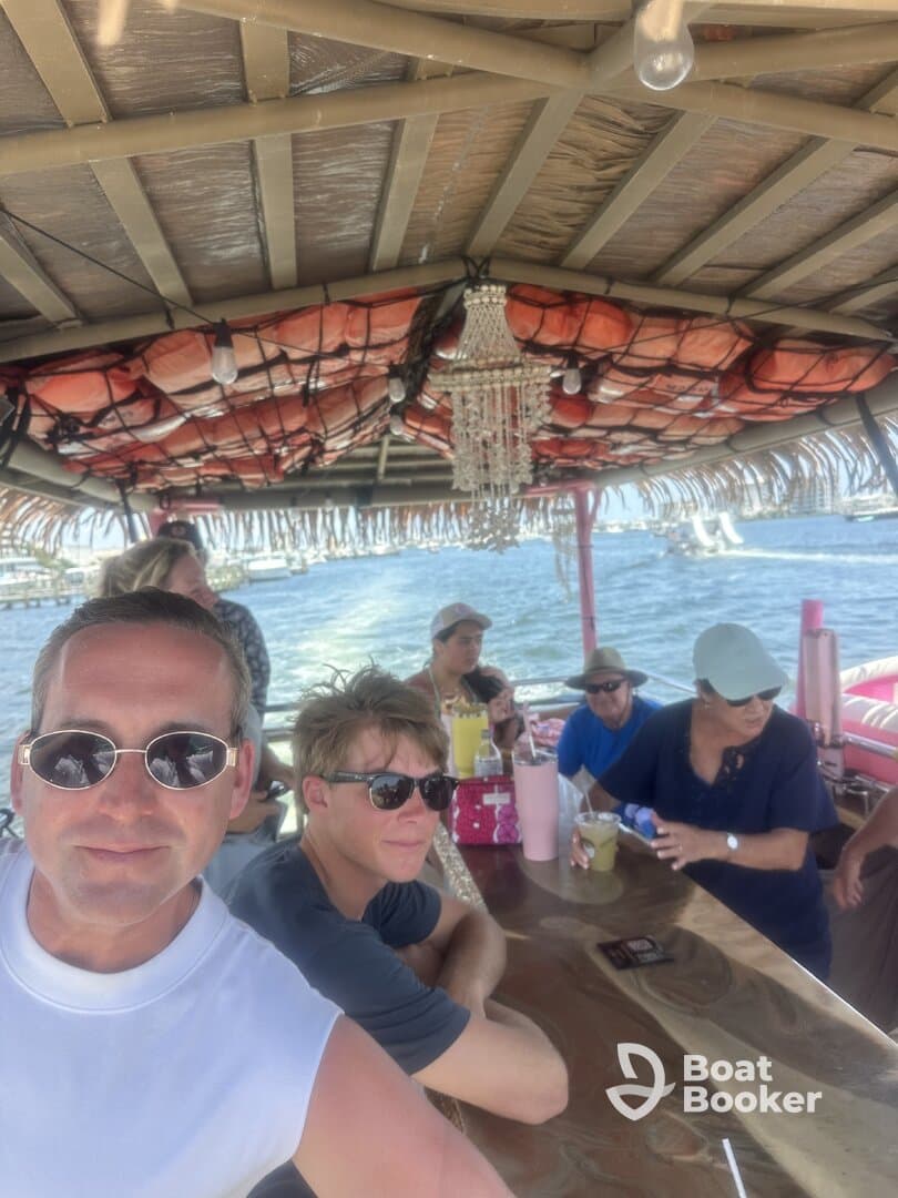 A lively group enjoys drinks aboard a boat, capturing the essence of a fun day on the water with friends and family.