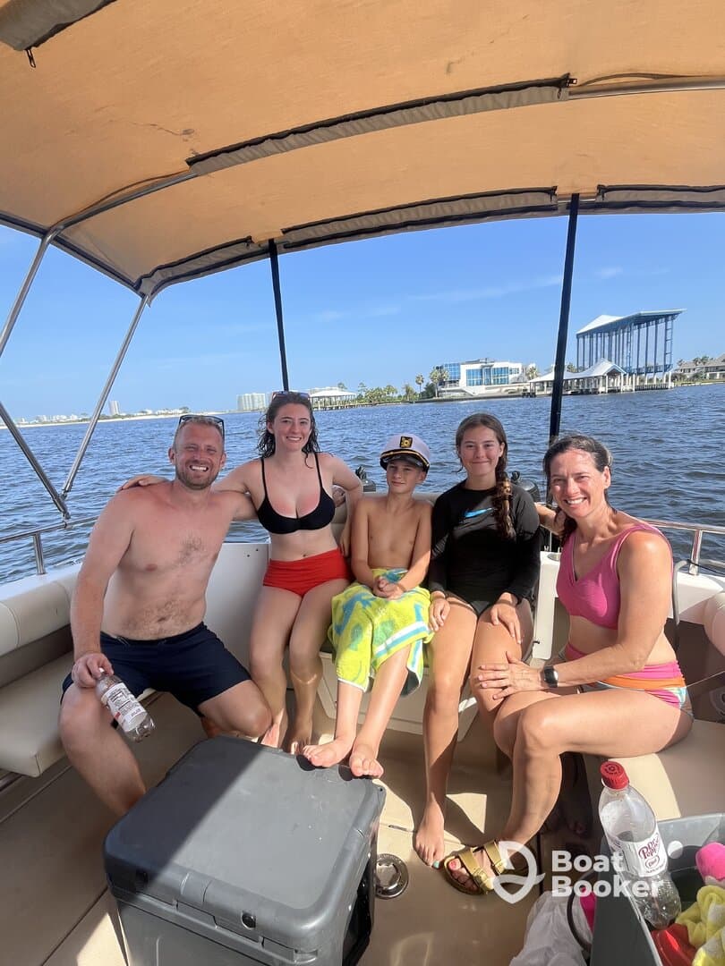 A joyful family enjoys their time on a boat, capturing a fun moment together under the sun — perfect for memorable summer outings.