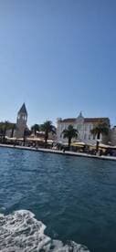 A picturesque view of a coastal town with palm trees and historic architecture, perfect for capturing the essence of a relaxing day on the water.