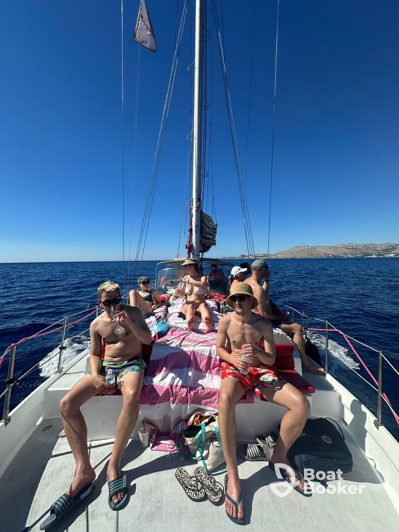 A lively group enjoys a day of sailing, relaxing on the deck under the sun — perfect for summer adventures on the water.