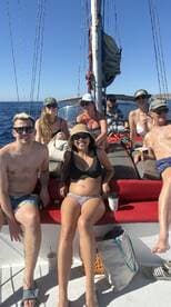 A lively group enjoys a sailing trip, soaking up the sun and celebrating together on the deck. Perfect for friends looking to create unforgettable memories on the water.