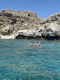 A group of friends enjoys a refreshing swim in crystal-clear waters, celebrating their day out in nature — perfect for summer adventures and memorable experiences.
