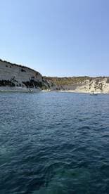 A stunning view of a serene coastline with white cliffs and clear waters, perfect for exploring by boat or enjoying a peaceful day on the water.