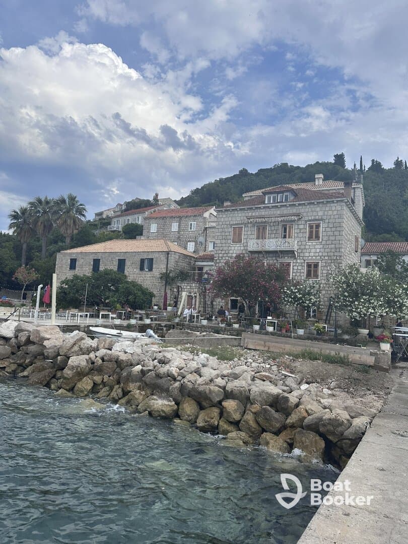 A scenic view of a coastal area with stone buildings and rocky shoreline, capturing the essence of a tranquil seaside destination.
