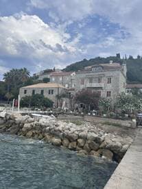 A scenic view of a coastal area with stone buildings and rocky shoreline, capturing the essence of a tranquil seaside destination.