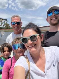 A joyful family takes a selfie on a boat, capturing a fun day out on the water — perfect for creating lasting memories together.