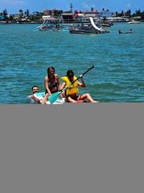 A group enjoys paddleboarding in vibrant waters, showcasing a fun day of water activities and camaraderie under the sun.