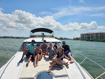 A lively group enjoys a sunny day on a boat, capturing the essence of fun and celebration on the water.