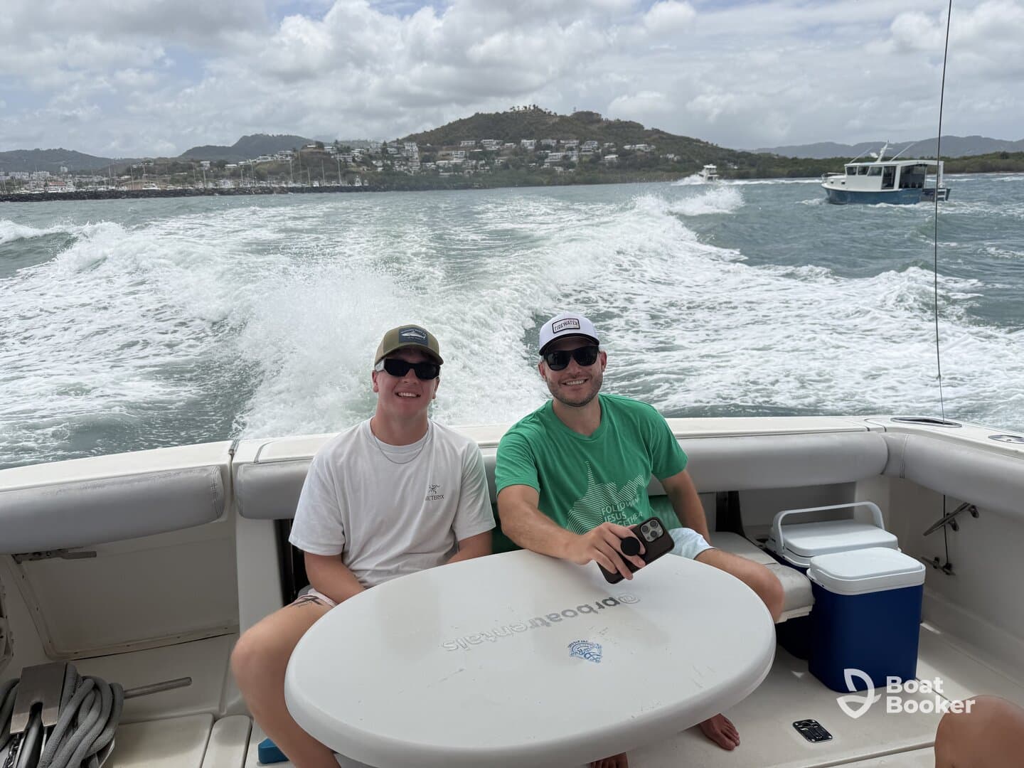 Two friends enjoy a day on the water, capturing the fun of boating with scenic views in the background — perfect for memorable outings and adventures.