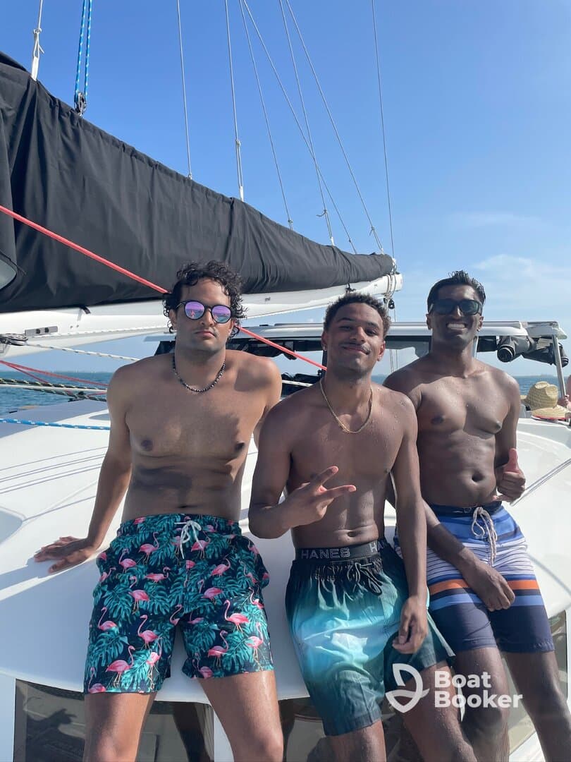 Three friends enjoy a sunny day aboard a catamaran, showcasing a fun and relaxed atmosphere perfect for summer adventures on the water.