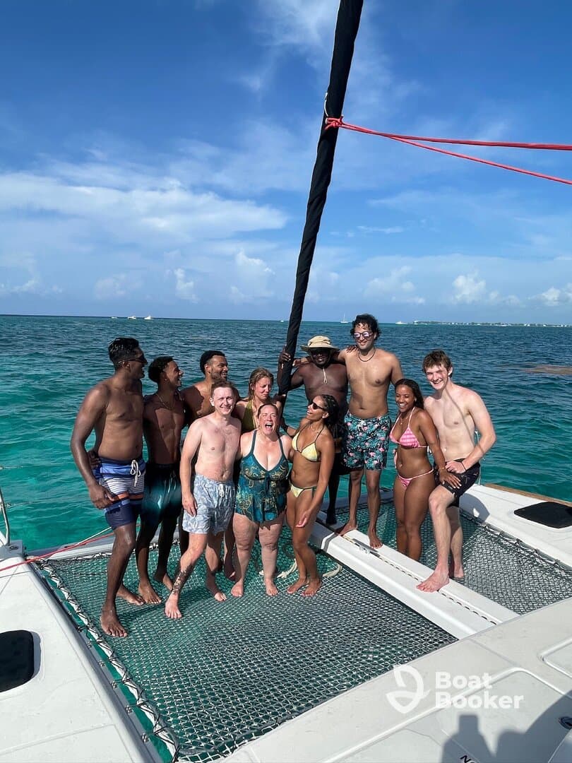 A joyful group of friends celebrates on the deck of a catamaran, enjoying the sun and water — perfect for memorable outings and adventures on the sea.