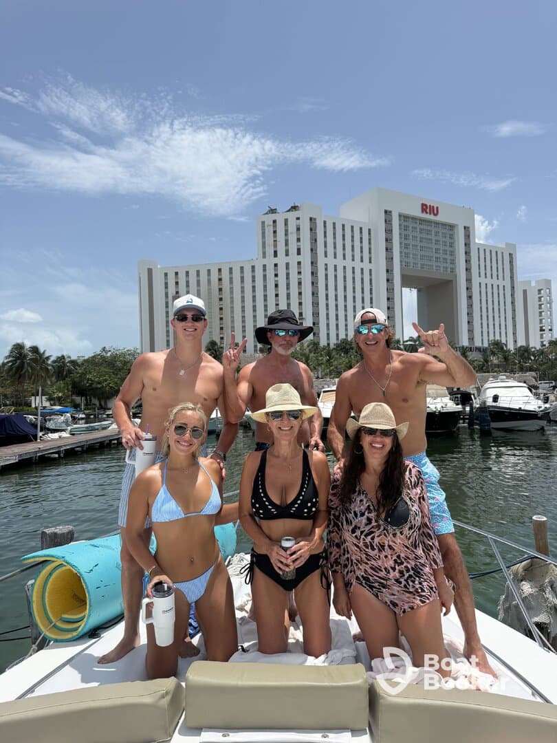A lively group of friends enjoys a sunny day on a boat, celebrating together with drinks and smiles, perfect for unforgettable summer memories.