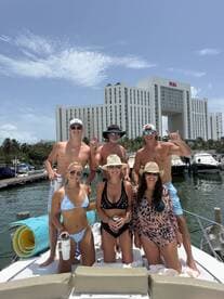 A lively group of friends enjoys a sunny day on a boat, celebrating together with drinks and smiles, perfect for unforgettable summer memories.
