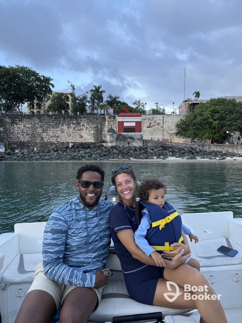 A joyful family enjoys a boat ride, with smiles all around and safety in mind as they wear life jackets. Perfect for family outings on the water.