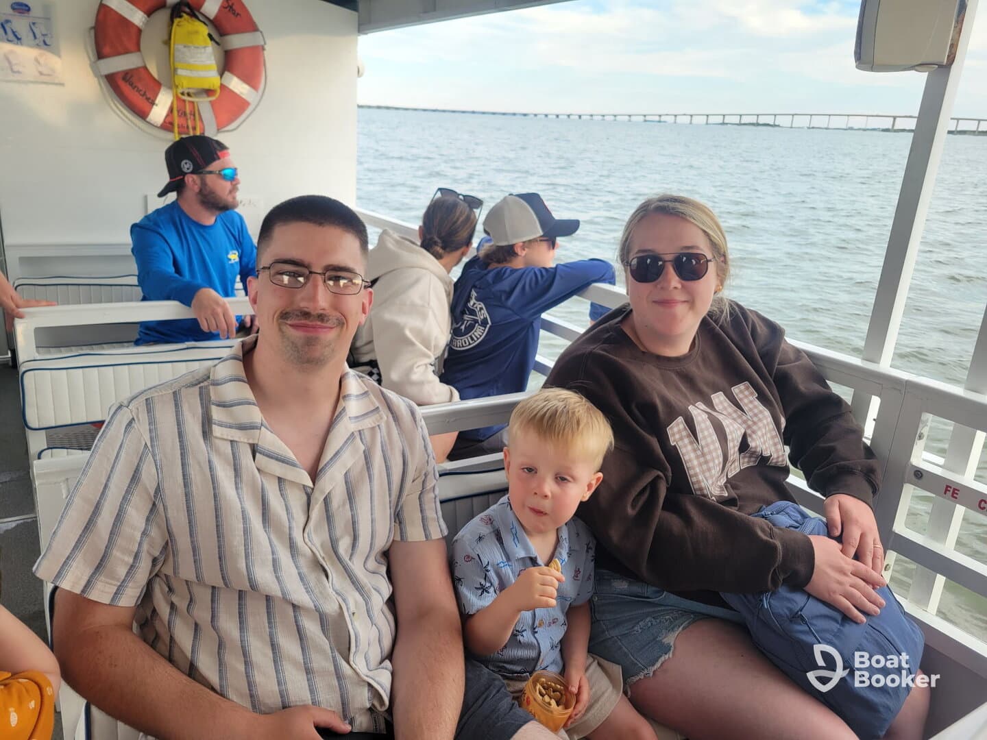 A family enjoys a boat ride together, with a child snacking and adults relaxing — a perfect moment for creating lasting memories on the water.
